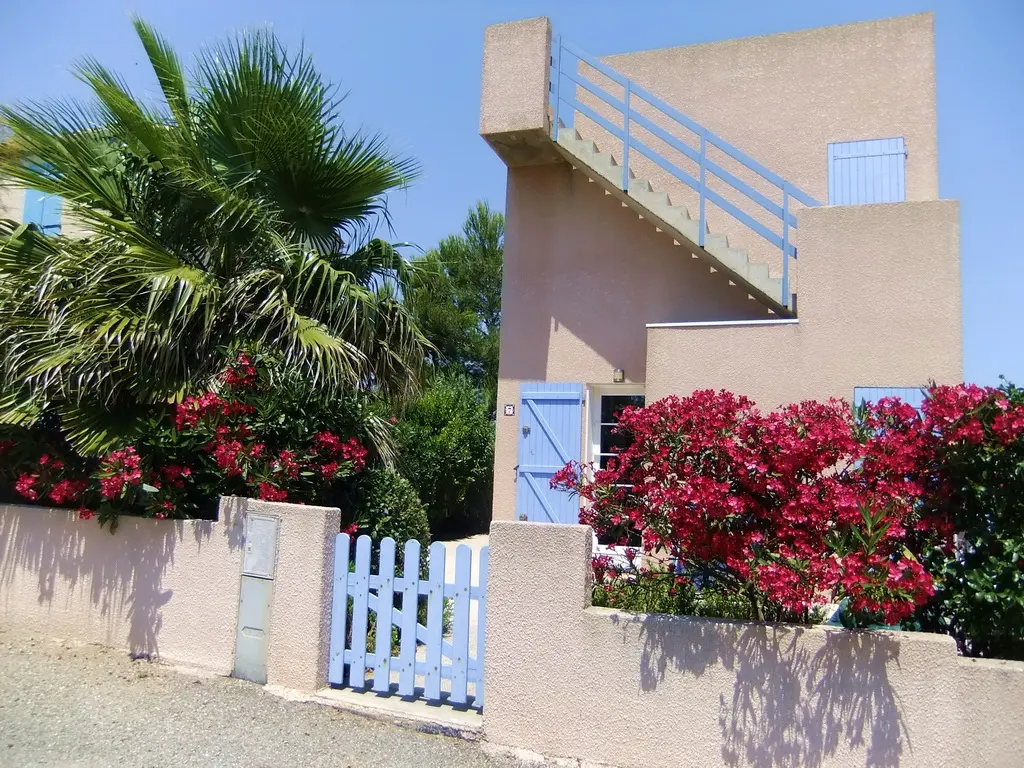 Eingang des Ferienhauses mit blauem Gartentor, Oleander und Treppe zur Dachterrasse