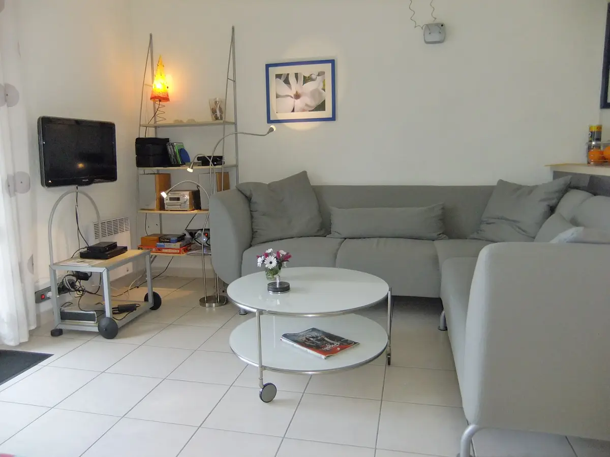 Heller Wohnbereich des Ferienhauses mit Ecksofa, TV und Stereoanlage